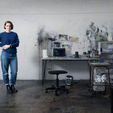 Fiona McMonagle standing in her studio with paint splatters on the white walls