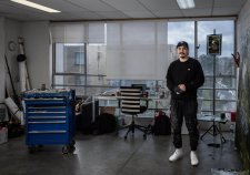 Abdul Abdullah in his studio with large windows overlooking a suburban street