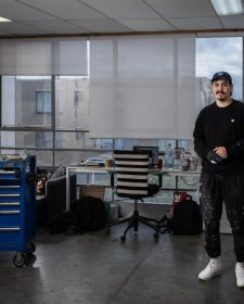 Abdul Abdullah in his studio with large windows overlooking a suburban street