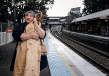 Latai Taumoepeau holding a blanket to her body while standing on the platform at a train station