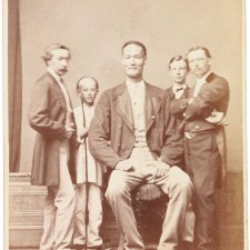 Chang the Chinese giant in European dress with Chinese boy and three European men, one of whom is his manager