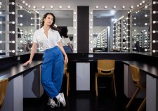 Amrita Hepi standing in front of a dressing room mirror surrounded by lights