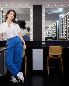 Amrita Hepi standing in front of a dressing room mirror surrounded by lights