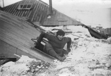 Mertz emerging from trap-door in roof, Australasian Antarctic Expedition, 1911-1914 Frank Hurley