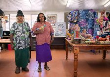 Dulcie Sharpe and Rhonda Sharpe in a room with a brown tile floor, next to a wooden table with soft animal sculptures